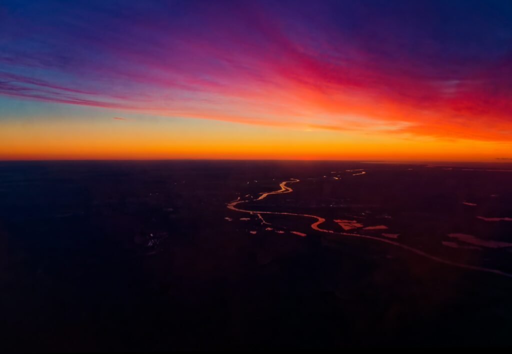 Vibrant sunset wallpaper with colorful sky and reflective winding rivers creating serene landscape