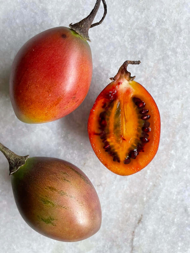 Fresh Tamarillo Wallpaper: Vibrant Trio on Textured Background