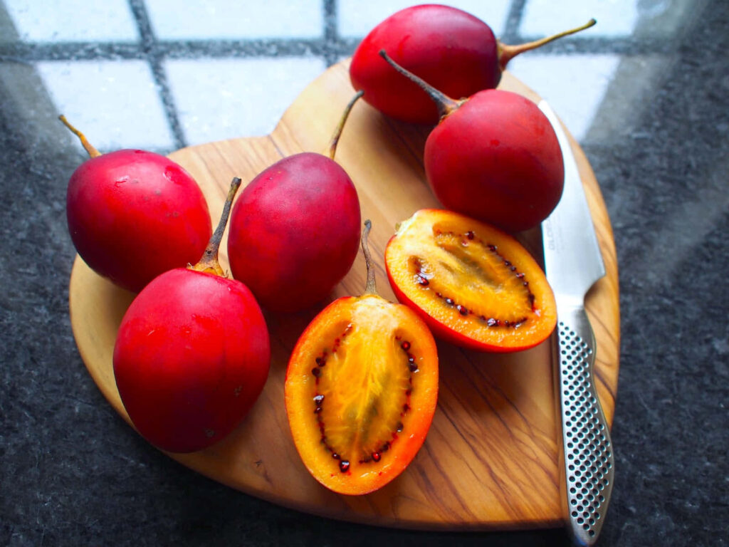 Vibrant Tamarillo Wallpaper: Colorful Fruits on Heart Platter