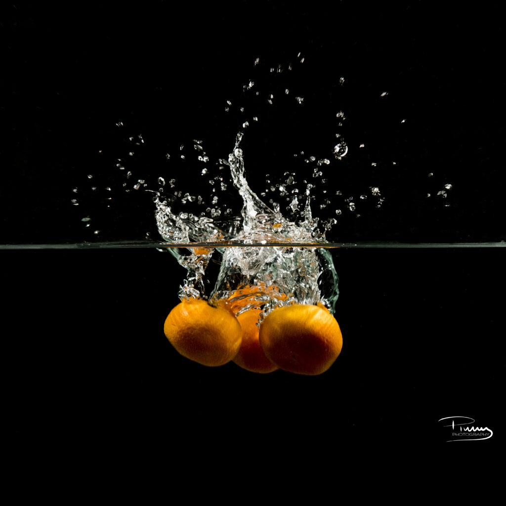 Vibrant Tangerine Wallpaper: Splashing Fruit Against Dark Background