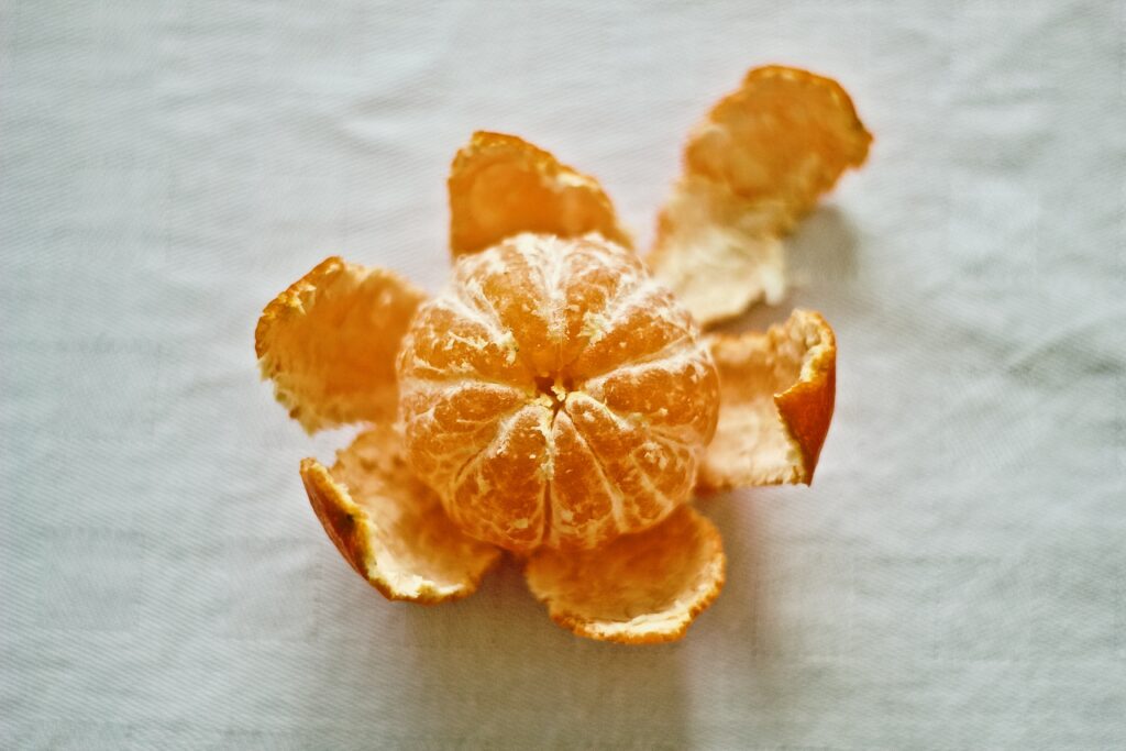 Fresh Tangerine Wallpaper: Vibrant Citrus Segments on Light Background