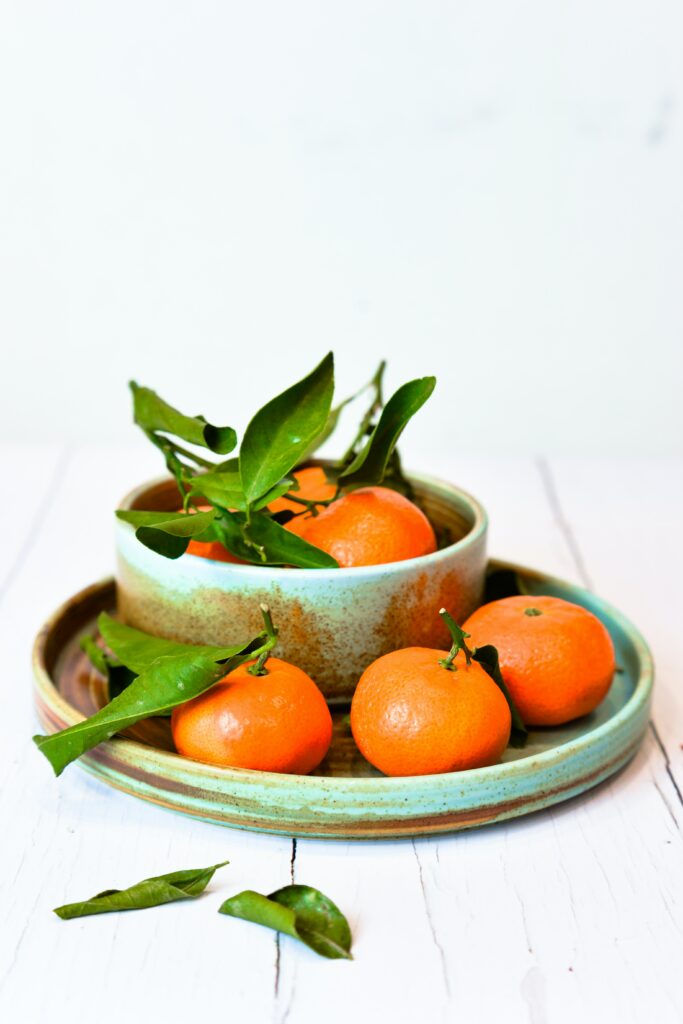 Refreshing Tangerine Wallpaper: Rustic Plates & Green Leaves Aesthetic