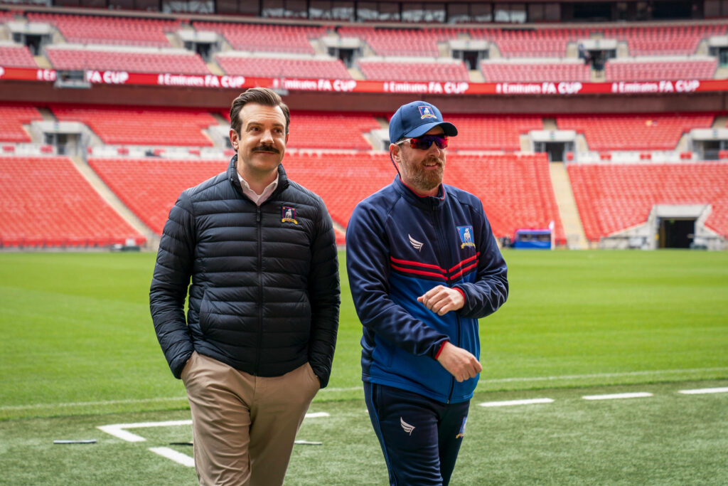 Ted Lasso Stadium Walk: Vibrant Football Ambiance Wallpaper
