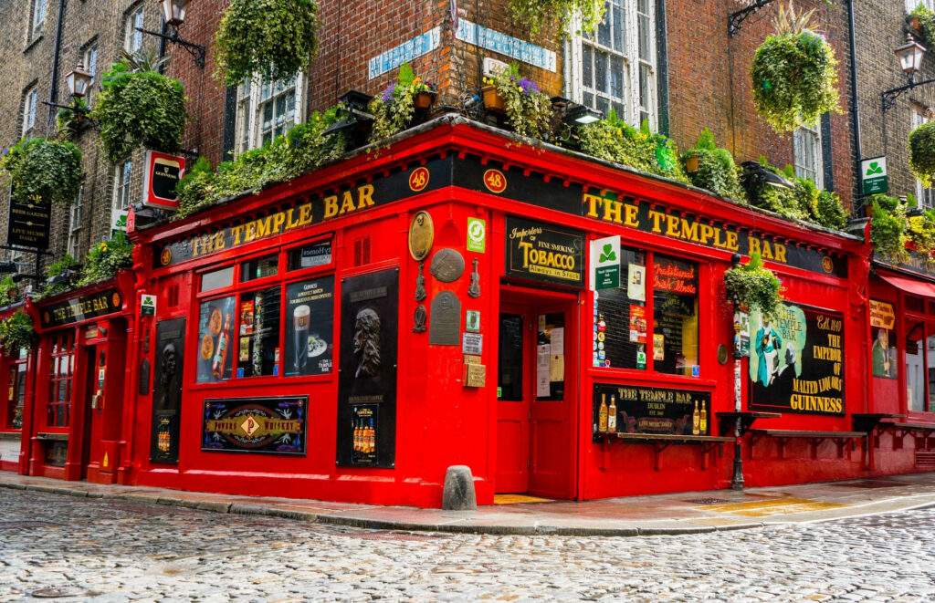 Vibrant Temple Bar Dublin wallpaper with red pub exterior lush hanging plants cobblestone street