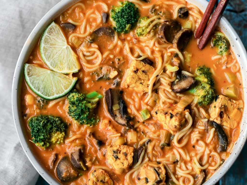 Vibrant Red Thai Curry Noodle Soup Wallpaper with Fresh Veggies