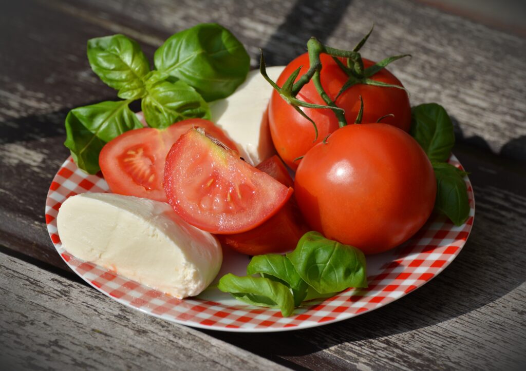 Vibrant Tomato Mozzarella Basil Wallpaper on Rustic Wood Surface