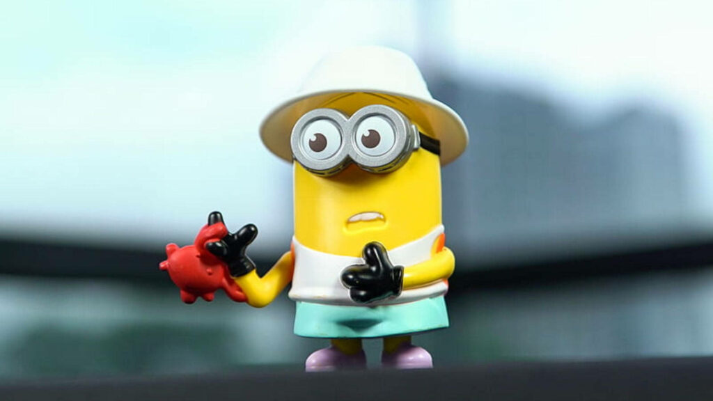 Vibrant Toy Dave Minion Wallpaper with Red Object & Blurred Nature