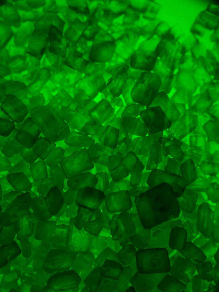 Vivid translucent green crystal stones wallpaper glowing with geometric shapes and sparkling textures