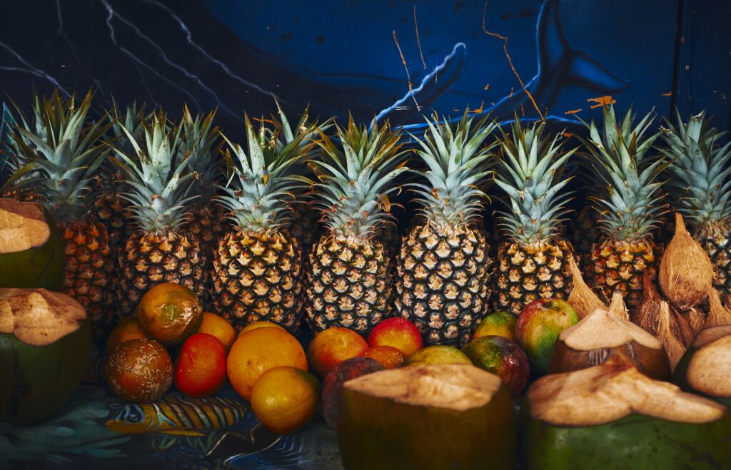Tropical Fruit Wallpaper: Vibrant Pineapples & Coconuts on Dark Backdrop