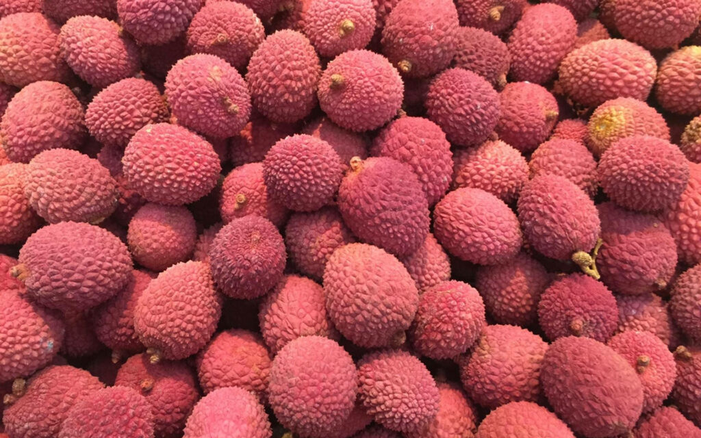 Exotic Pink Oval Lychees Wallpaper - Vibrant Tropical Background