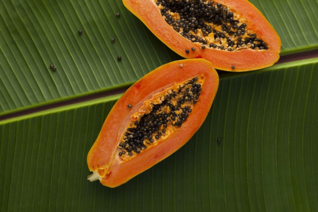 Tropical Papaya Wallpaper: Fresh Fruits on Banana Leaf Background