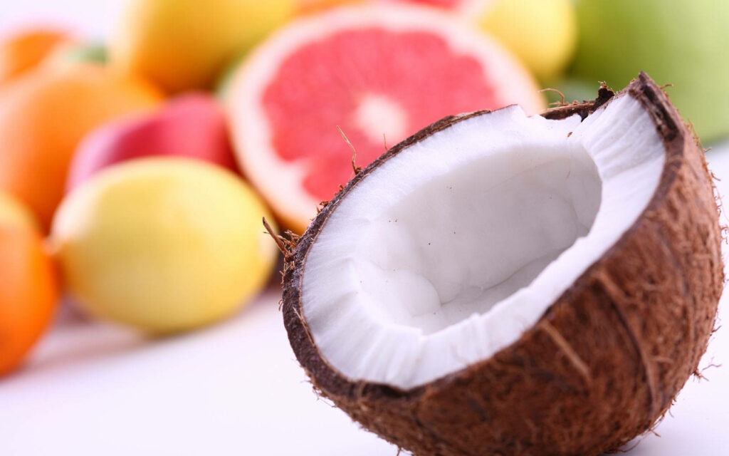 Tropical Wallpaper: Halved Coconut with Colorful Fruits Background