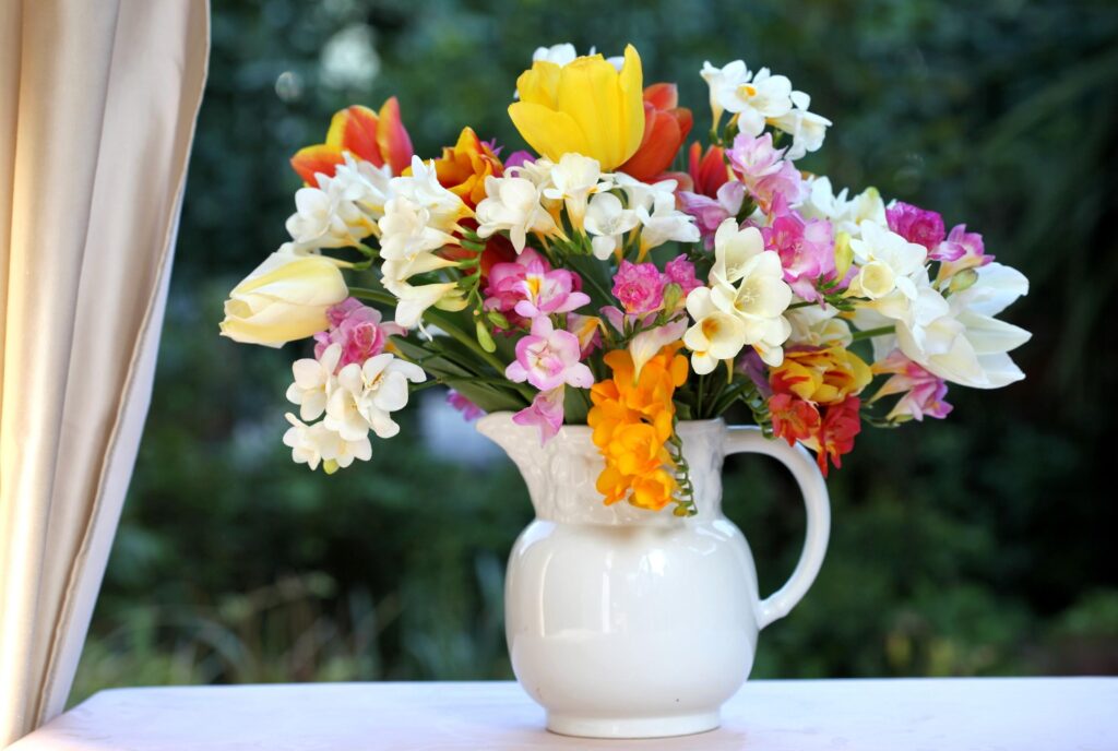 Vibrant Tulip and Freesia Wallpaper in White Jar Against Nature