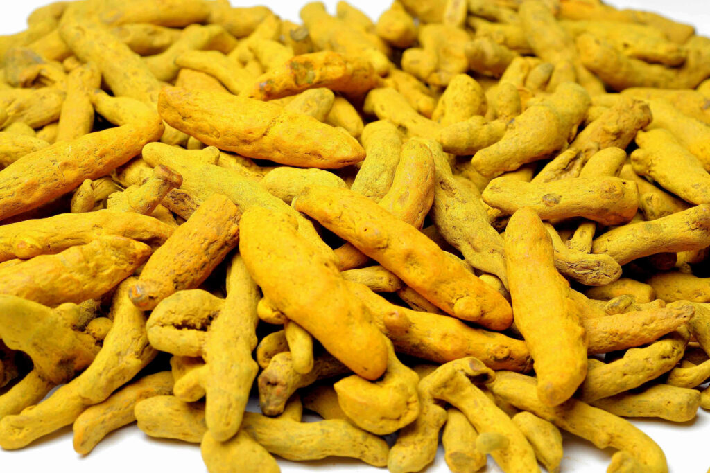 Vibrant Turmeric Rhizomes Wallpaper: Bright Yellow-Orange Spice Art