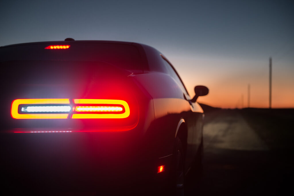 Sleek Car at Twilight: Vibrant Taillights & Serene Sky Wallpaper