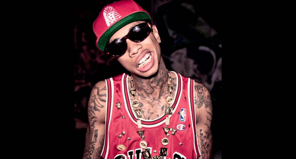 Vibrant Tyga Wallpaper: Intense Look in Red Cap & Stylish Jersey