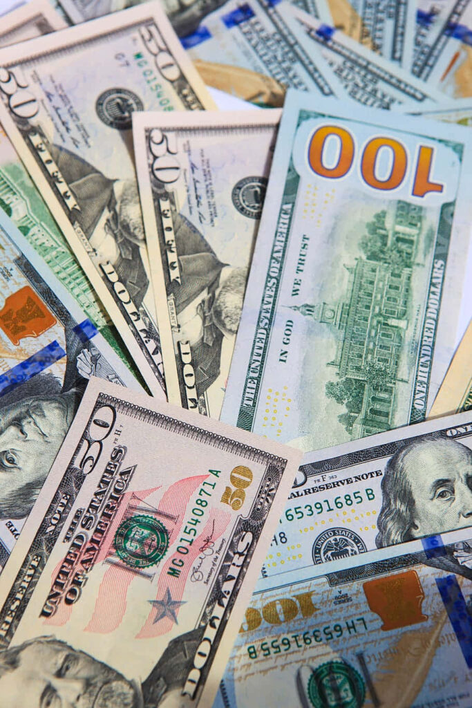 Scattered US dollar bills showing vibrant currency details and security features background Wallpaper