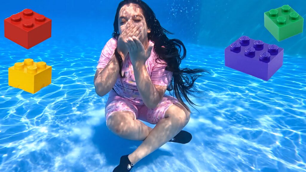 Vibrant wallpaper of Shfa underwater in pool with colorful floating toy blocks playful scene