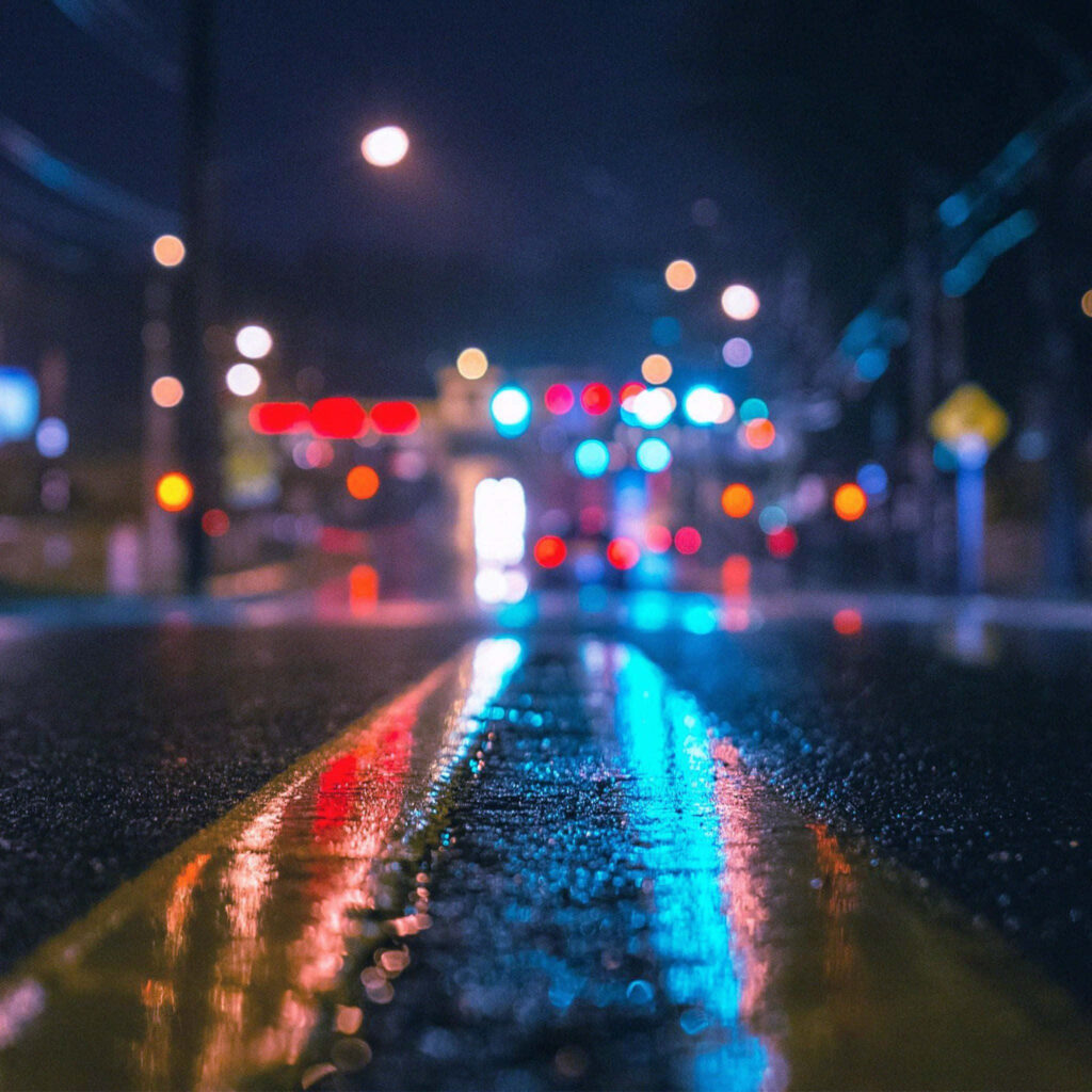 Vibrant Night Cityscape: Neon Lights & Reflective Wet Pavement Wallpaper
