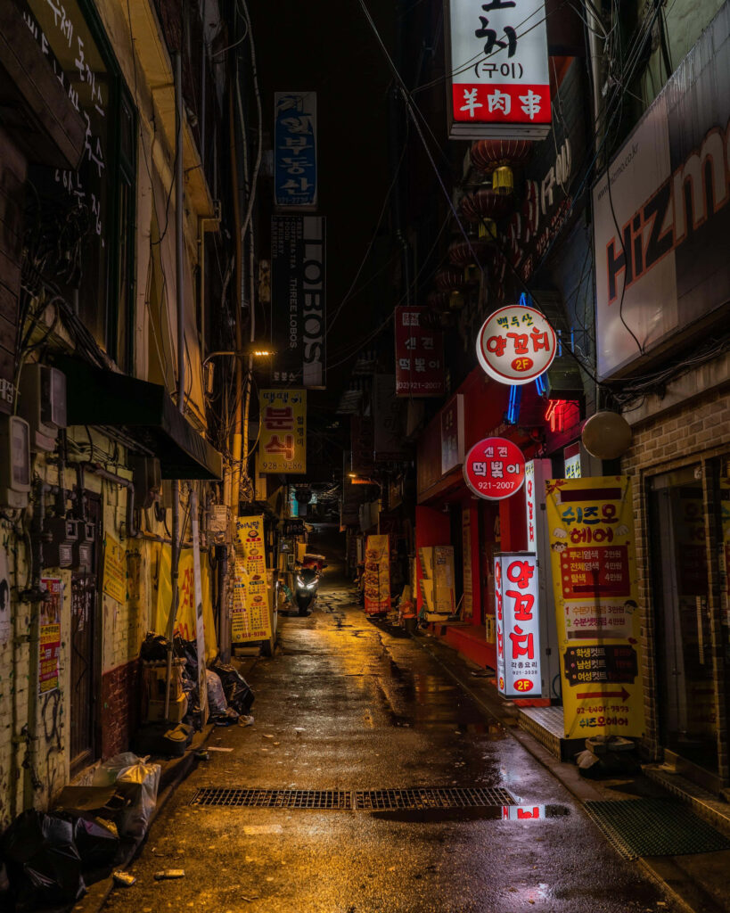 Vibrant Urban Night Scene: Moody Alley with Colorful Signage Wallpaper