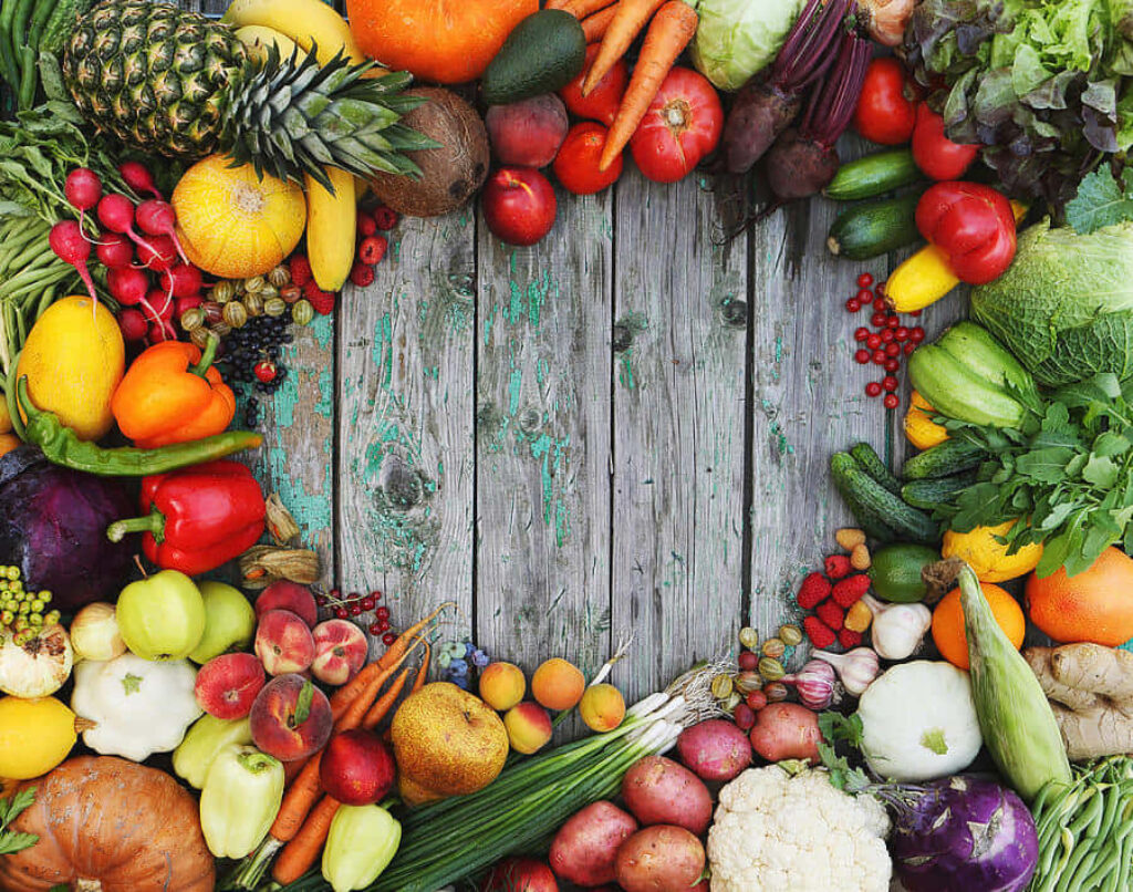 Vibrant Fresh Fruits & Vegetables Wallpaper Over Rustic Wood Background