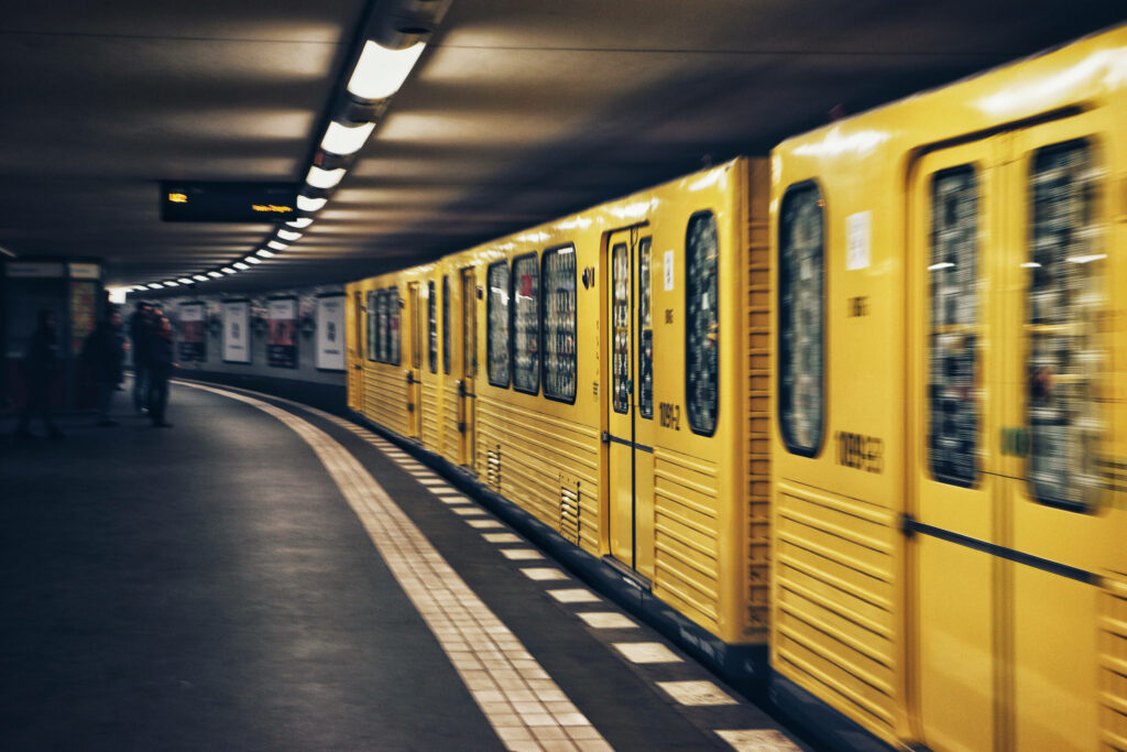 Electric Surge: A Vibrant Yellow Subway Train Racing Through the Urban Jungle Wallpaper