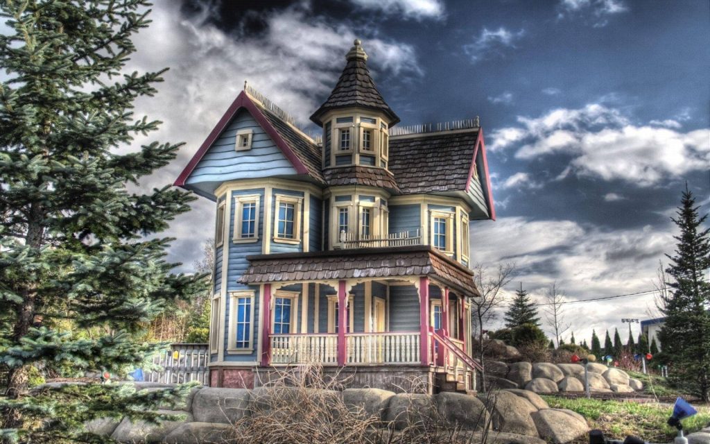 High-contrast Victorian house wallpaper with blue siding cream trim purple accents HDR sky