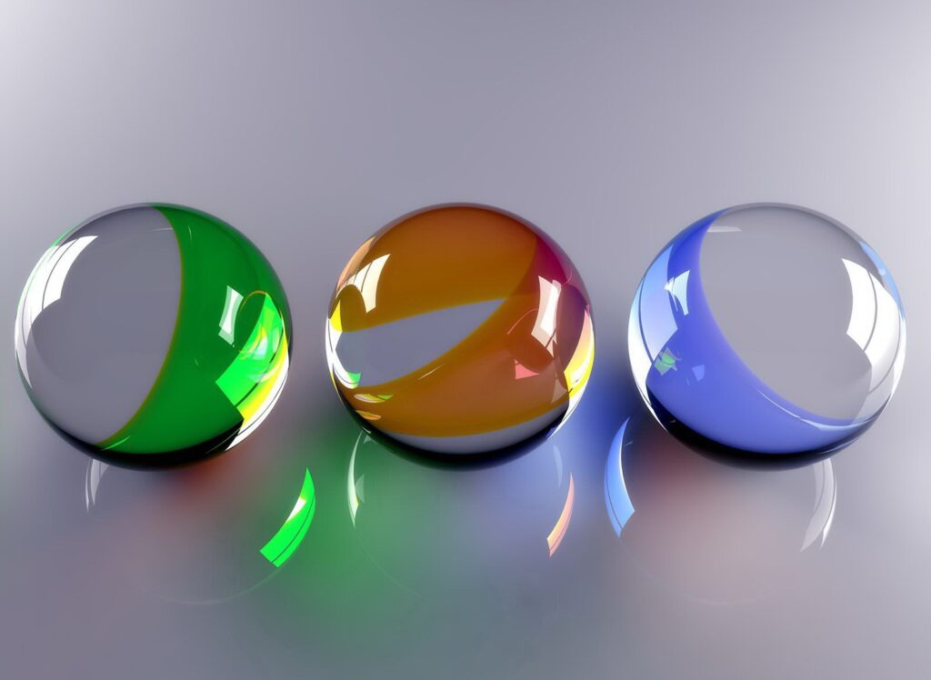 Vibrant Background: Colorful Glass Balls in Green, Orange, and Blue Wallpaper