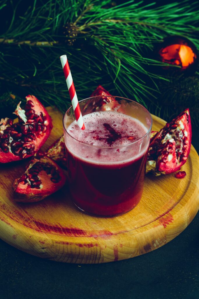 Vibrant Pomegranate Juice Wallpaper with Striped Straw & Slices