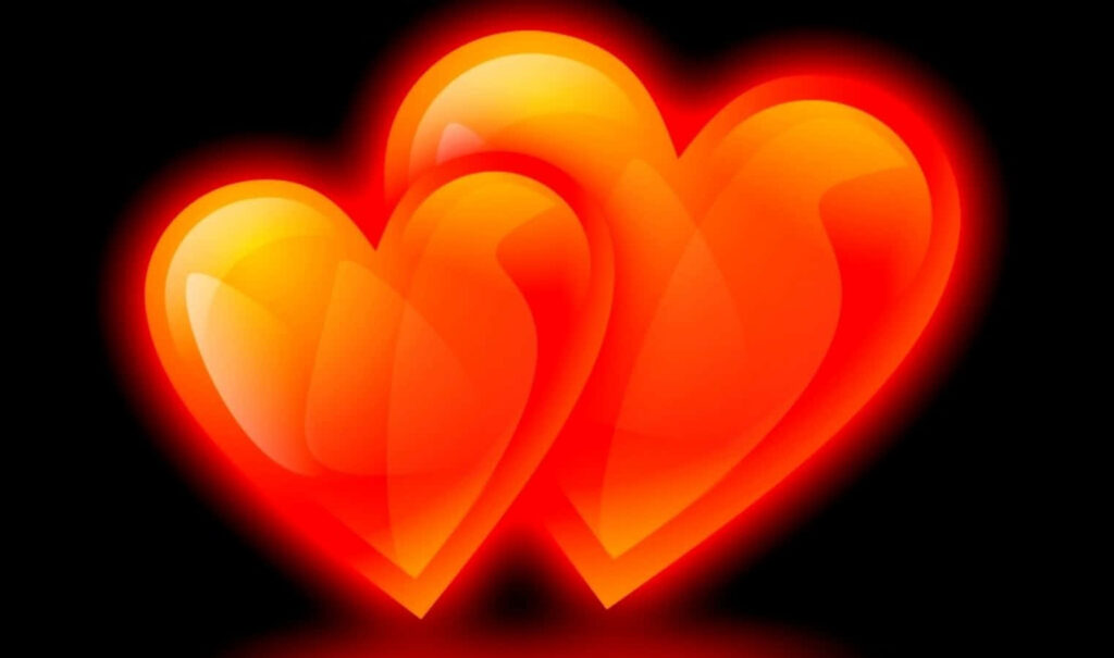 Vibrant Wallpaper: Two Glowing Orange Hearts on Dark Background