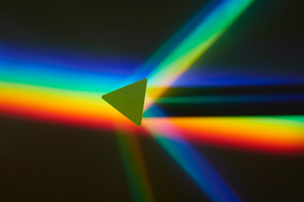 Colorful Rainbow Streaks on Dark Background with Central Green Triangle Wallpaper