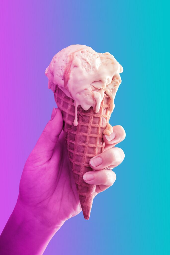 Vibrant Wallpaper: Hand Holding Melting Ice Cream Cone on Gradient