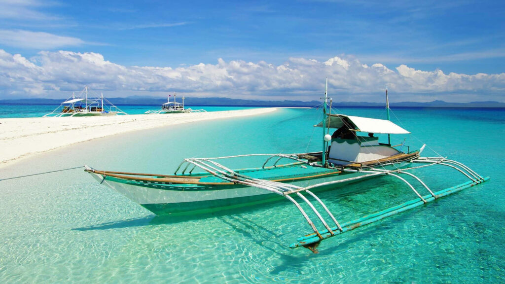 Vibrant Wallpaper: Outrigger Boat in Turquoise Waters & Blue Sky