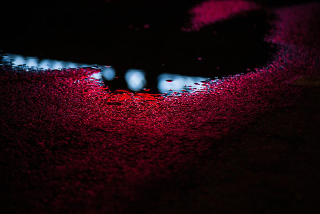 Vibrant Wallpaper: Colorful Puddle Reflections on Dark Textured Surface