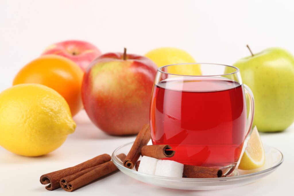 Vibrant Wallpaper: Glass Cup with Fruits & Cinnamon Sticks