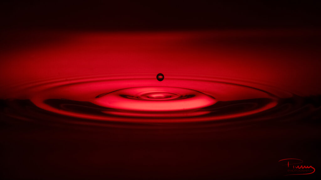 Mesmerizing Water Droplet Wallpaper: Red Liquid Ripples in Mid-Air