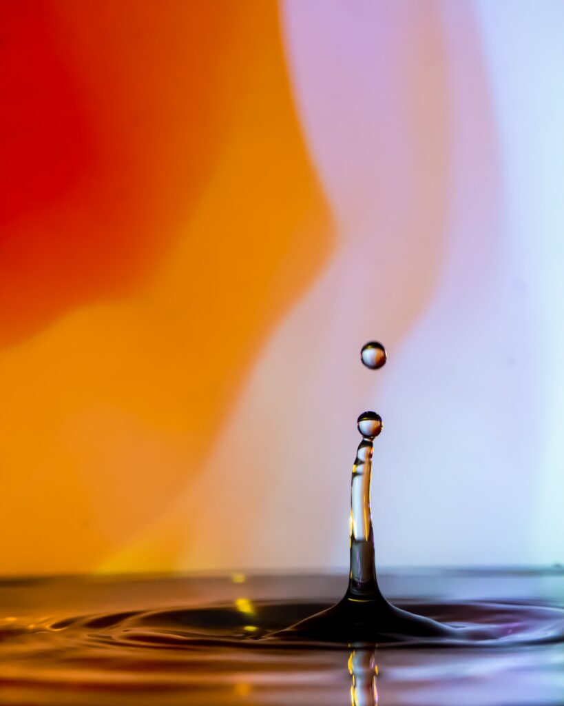 Vibrant Water Droplet Wallpaper: Close-Up Ripples in Bold Hues