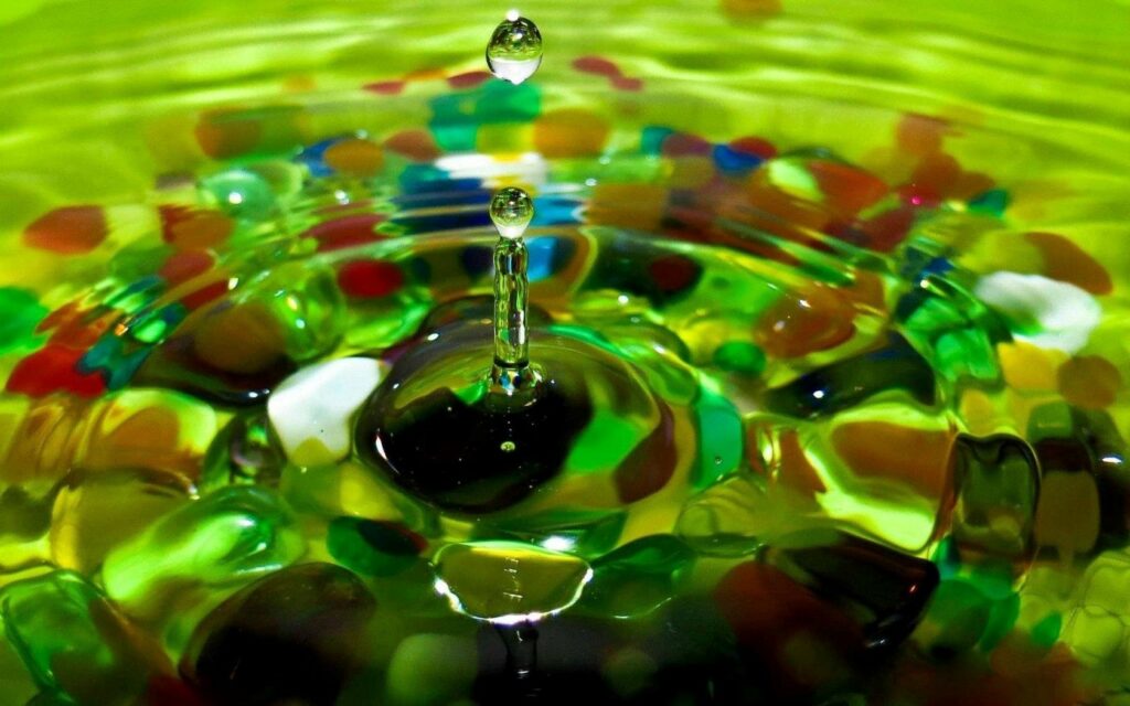 Vibrant Water Droplet Wallpaper with Colorful Stones & Green Background