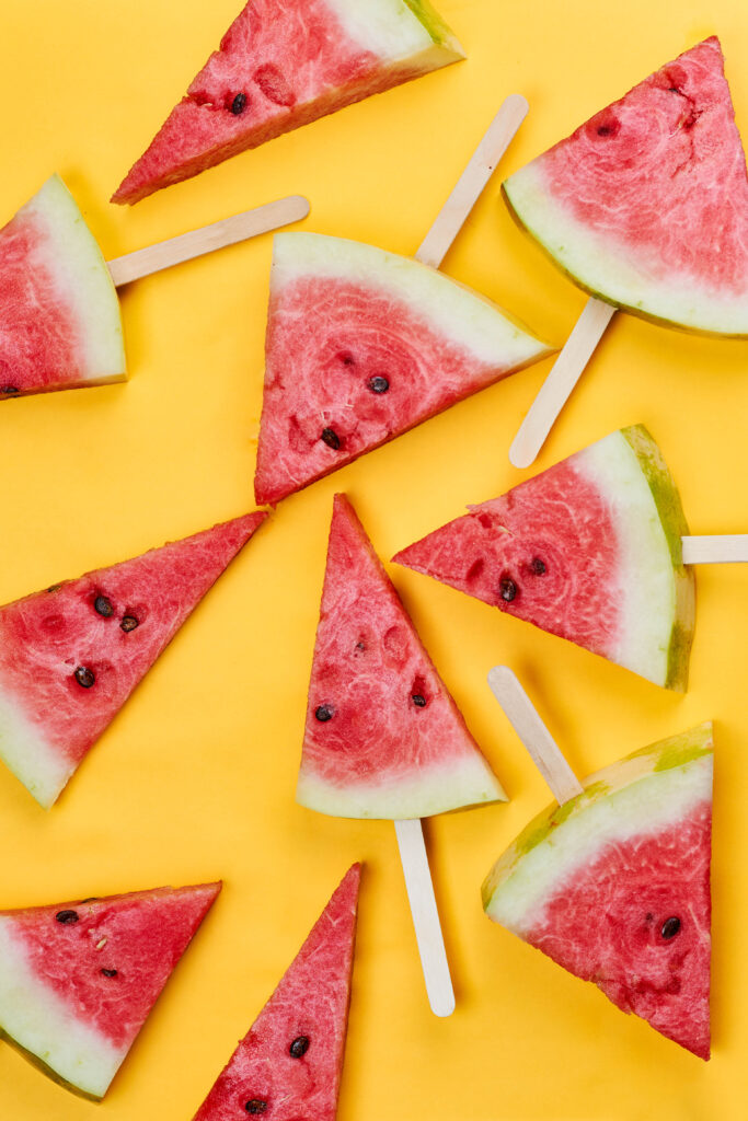 Vibrant Red Watermelon Slices on Bright Yellow Wallpaper Background