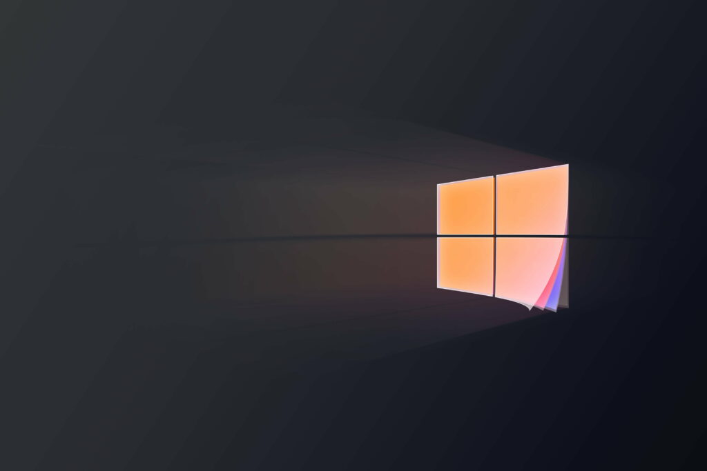 Minimalist Microsoft Windows logo wallpaper glowing orange on dark charcoal background with curl effect