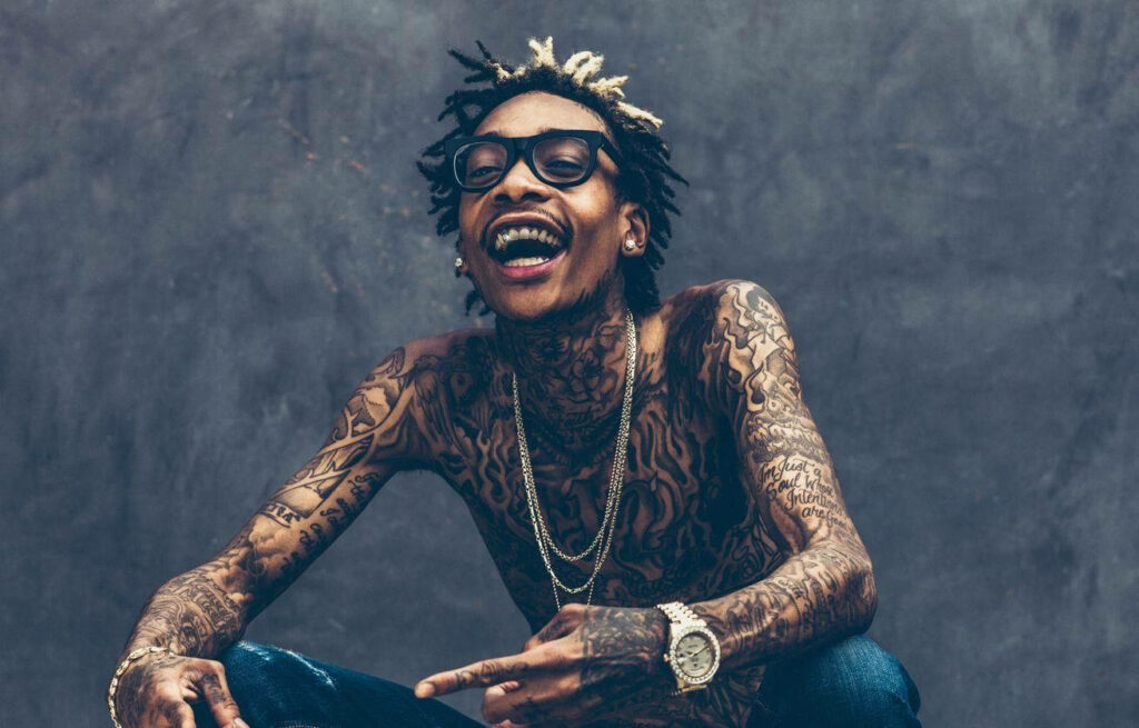 Vibrant Wiz Khalifa Wallpaper: Laughing with Tattoos on Minimalist Background