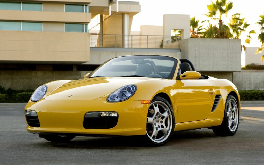 Vibrant Yellow 2008 Porsche Boxster Convertible in Urban Setting Wallpaper