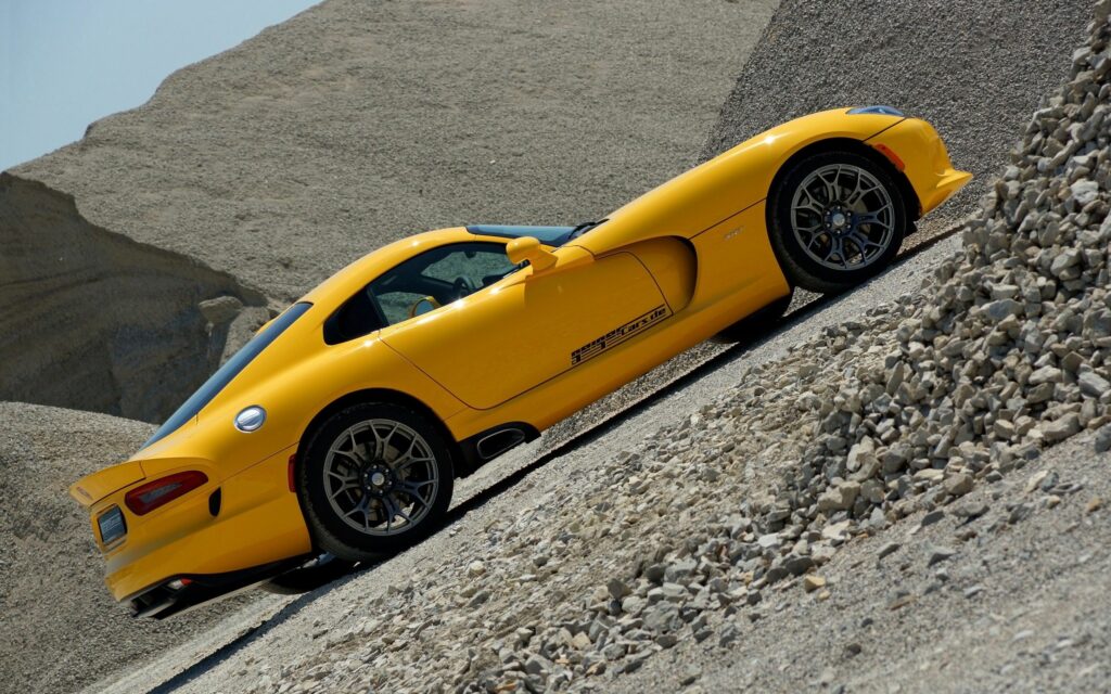 Vibrant Yellow 2013 Dodge Sports Car in Rocky Terrain Wallpaper