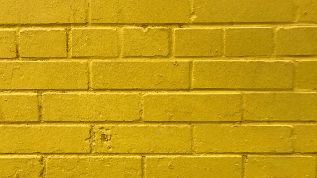 Vibrant Yellow Brick Wall Wallpaper: Textured Surface & Bold Patterns