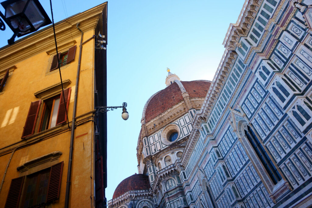 Vibrant Yellow Building Wallpaper Against Historic Dome Facade