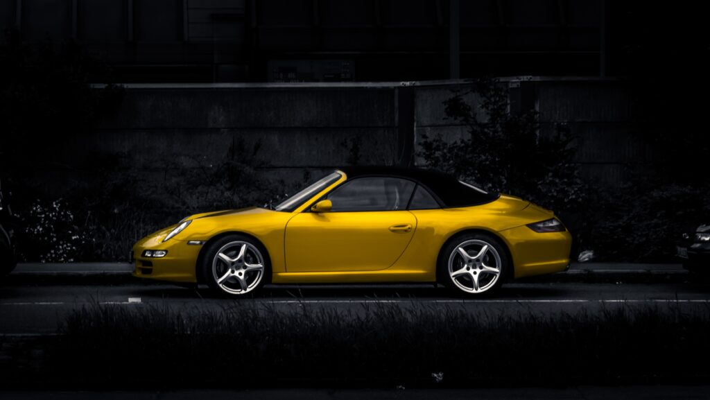 Sleek Yellow Car Side View Wallpaper on Dark Background