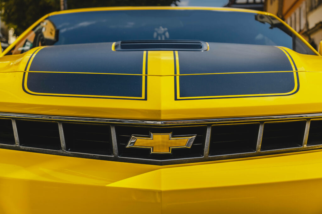 Vibrant Yellow Chevrolet Hood with Bold Black Racing Stripes Wallpaper