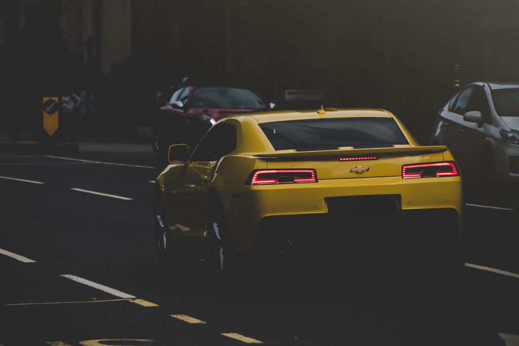 Vibrant Yellow Chevrolet Wallpaper: Sleek Car on Dimly Lit Road