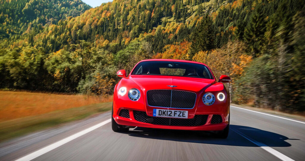 Cool Red Bentley Car on Road Background Wallpaper