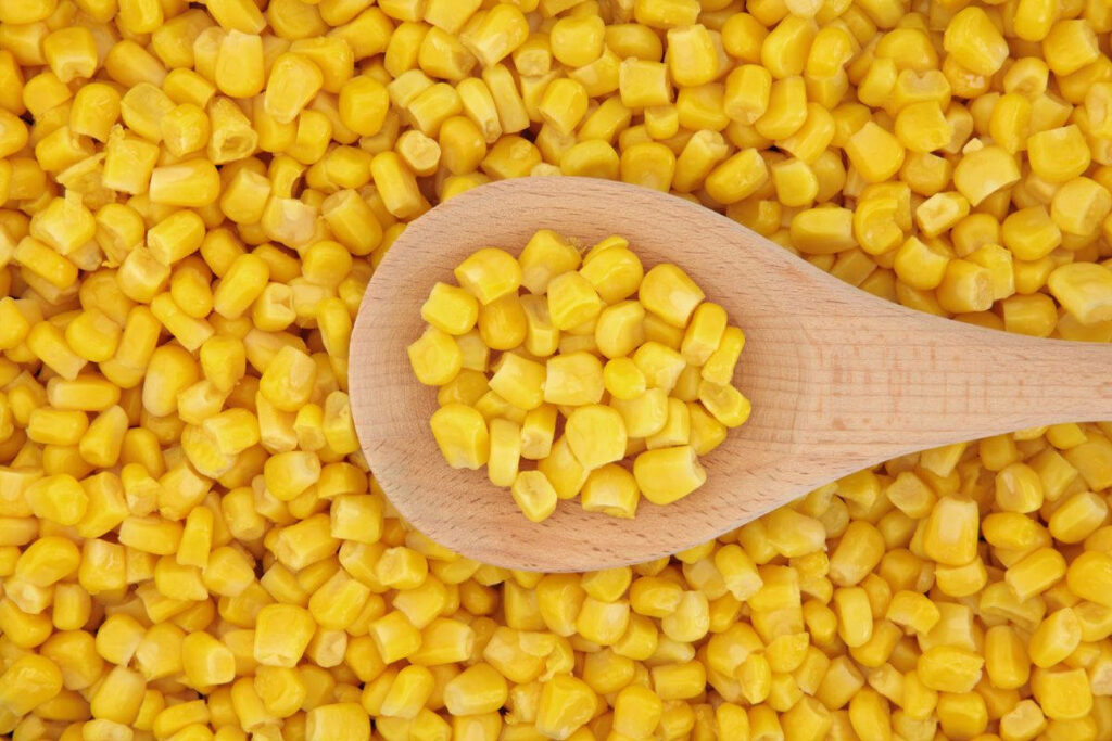 Vibrant Yellow Corn Wallpaper: Close-Up on Wooden Ladle & Kernels